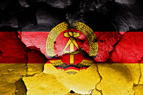 флаг восточной германии нарисован на треснувшей стене - east germany стоковые фото и изображения