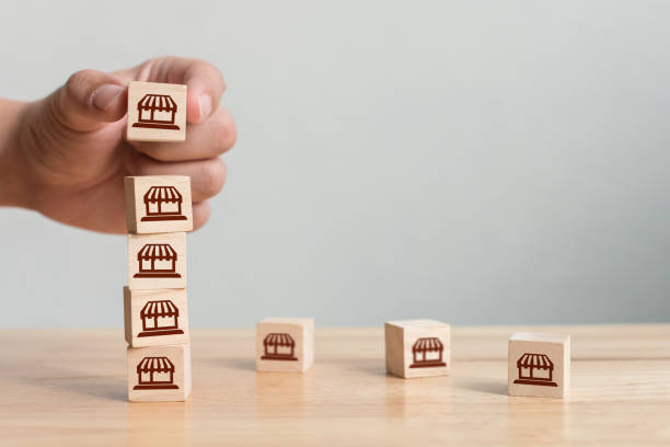 istock Franchise business marketing system concept. Structure service store network strategy. Hand putting wooden block on top with icon store 1263567079