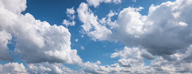 Panoramic cloudscape background with blue sky and white clouds in summer. Whide image.