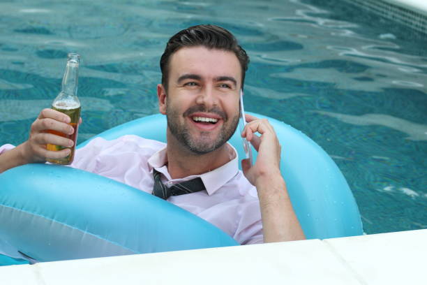 istock Happy businessman making a call in swimming pool 1263568694