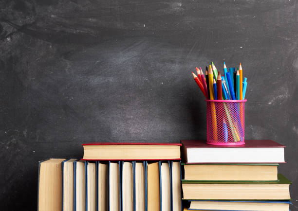 istock stack of various books, stationery on black chalk board background, back to school 1263571920