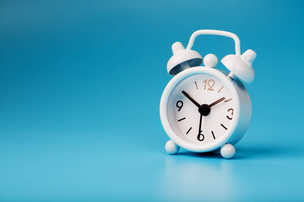 istock White retro alarm clock on blue background. Concept of time with free space for text. 1263573011