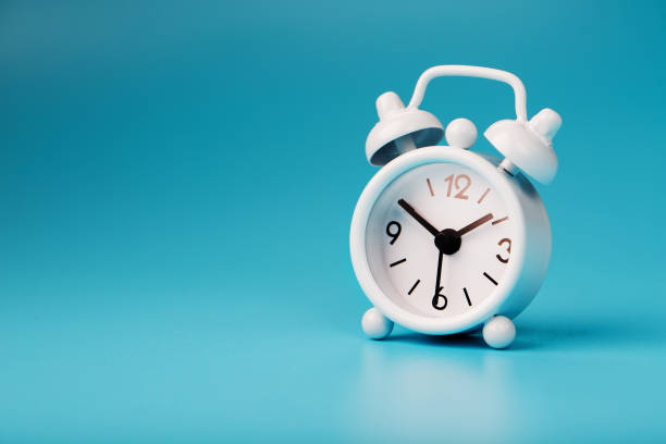 istock White retro alarm clock on blue background. Concept of time with free space for text. 1263573883