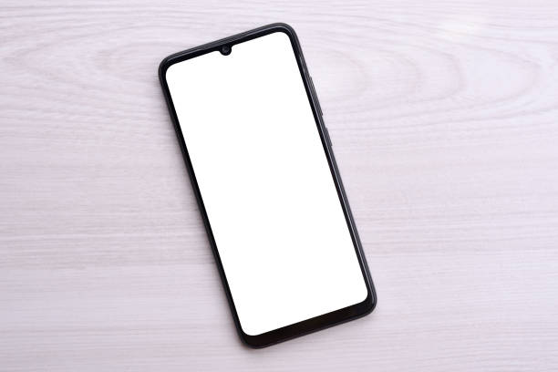 istock Mobile phone smartphone with white screen for your text, image on a bright defective table 1263577116