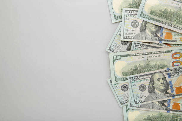 istock A pile of hundred dollar bills on grey background with copy space 1263581328