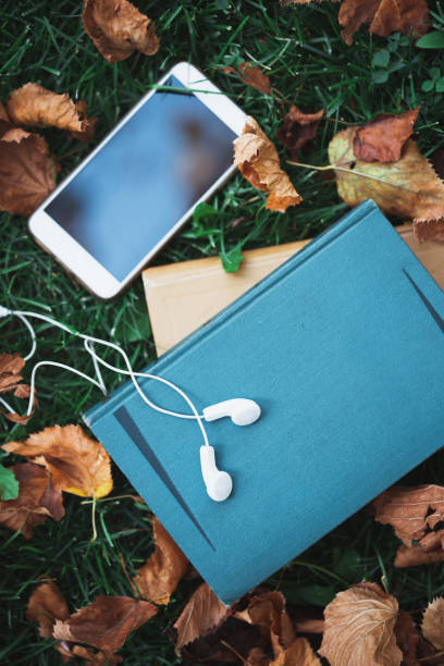 istock books smartphone and earphones on grass. fall and relax