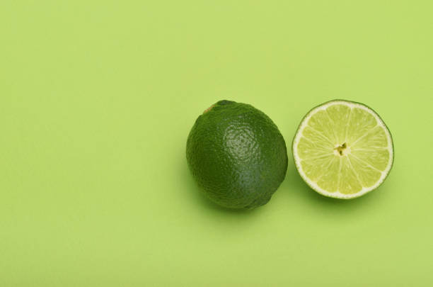 fetta di lime su sfondo verde - lemon portion cross section isolated foto e immagini stock