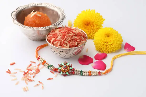rakhi a thread decorated with beads is tied to brother by his sister on the traditional occasion of Raksha bandhan an Indian festival. Rakhi with elements pooja like sweet, rice grains, kumkum,flowers