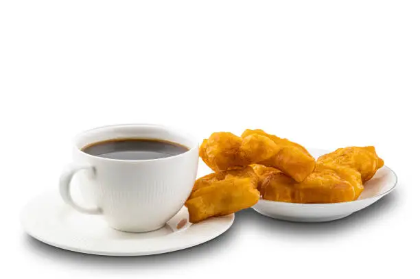 Photo of Cup of black coffee and pile of deep-fried dough stick.