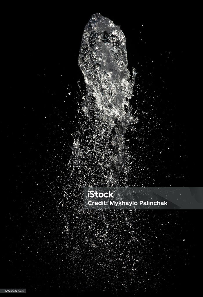 Jet of water in a fountain Abstract background with water drops. Jet of water in a fountain on a black background Water Stock Photo