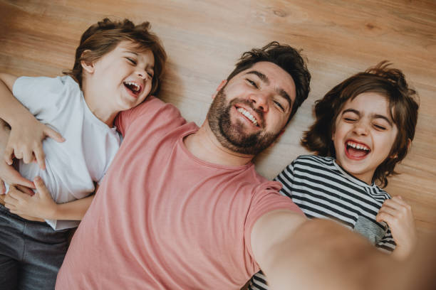 Father having fun with kids and making selfie at home