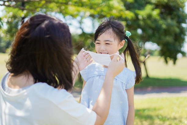 istock Mother putting a mask on child 1263612907