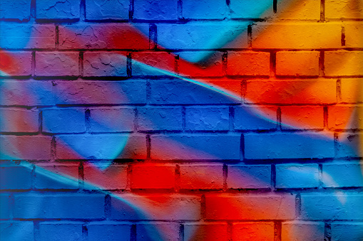 Bright abstract scenic background, double exposure of neon lights of a modern city and a brick wall, like a painted graffiti. Modern trendy pattern, wallpaper or banner design