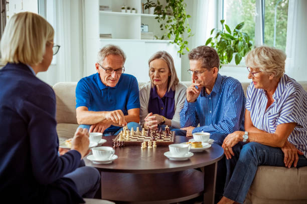 istock Senior people playing chess in retirement house 1263620165