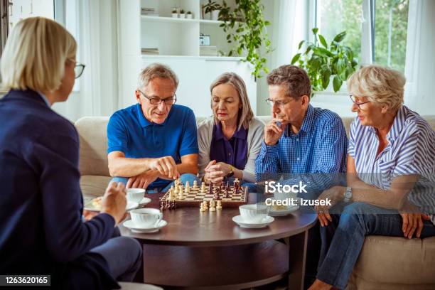 Senior People Playing Chess In Retirement House Stock Photo - Download Image Now - 70-79 Years, Adult, Aging Process