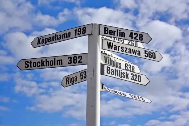 A signpost showing directions and distances to different European cities. Photo taken in Landskrona, Sweden.