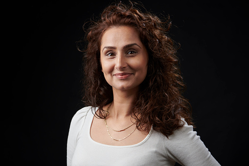 Studio portrait of Pakistani woman on black background standing looking at the camera