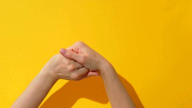 istock a woman who is rubbing her hands on a yellow background 1263623925