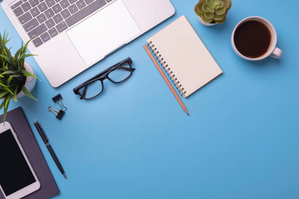 istock Blue office desk with laptop, and smartphone with pen and notebook on a table 1263625678