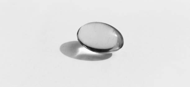単一の黒と白のタラの肝臓油または魚油ゲルカプセル。 - hair gel capsule cod liver oil pill ストックフォトと画像