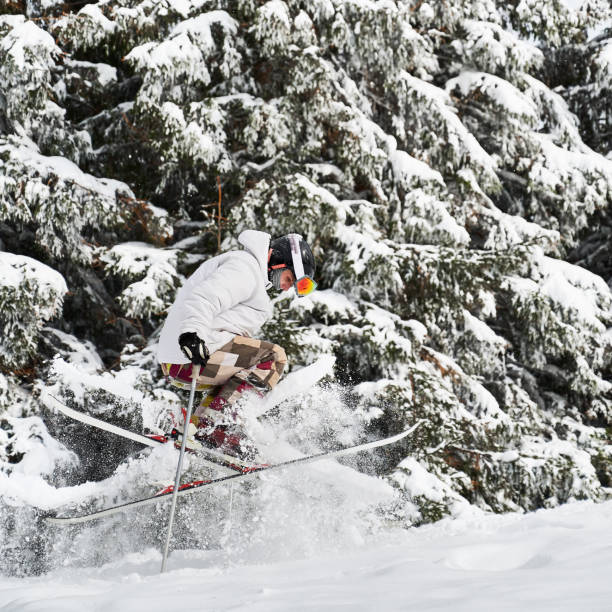 зимние виды спорта. лыжник делает трюки в горах в зимний сезон - powder snow skiing agility jumping стоковые фото и изображения