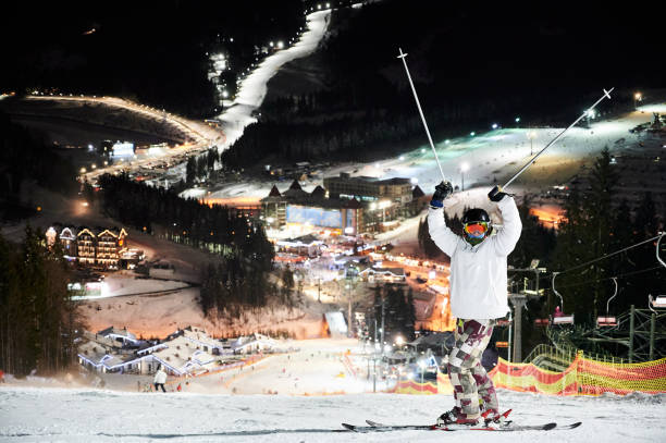 istock Man skier standing on snowy hill at night. 1263627773