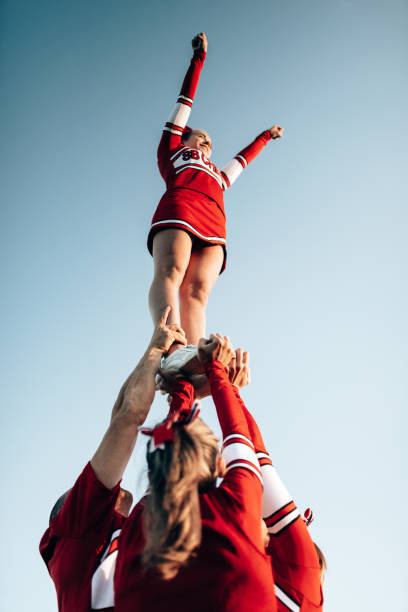 cheerleader-team, das eine leistung erstellt - einen trick durchführen stock-fotos und bilder