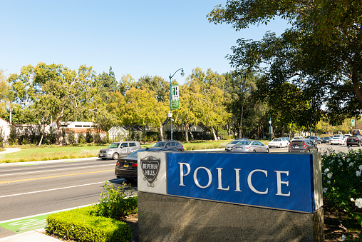 Beverly Hills, California, United States - October 20, 2019: Image with the Beverly Hills Police sign, along with nature and cars on the road in Beverly Hills, California - United States