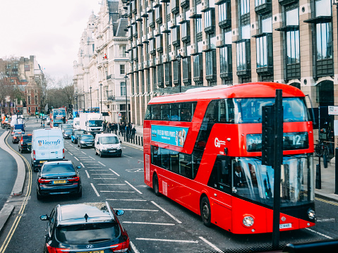 London, UK - 12 14 2017: Red double-decker bus in London city center street traffic. The red double-decker buses in London have become a national symbol of England and United Kingdom.