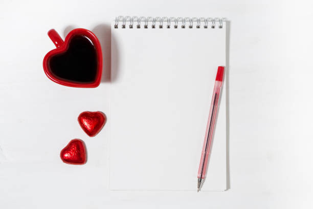 istock cup of coffee, chocolate candy and a notepad on a white background, top view 1263632591