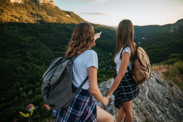 Two little girls holding hands while hiking together