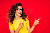 Beautiful girl on the red background showing right direction with her fingers