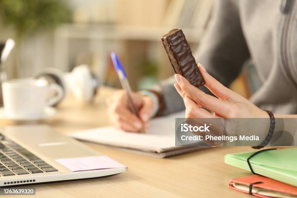 Student Hands Holding Chocolate Snack Bar Studying Stock Photo - Download Image Now - Chocolate, Eating, Bar - Drink Establishment