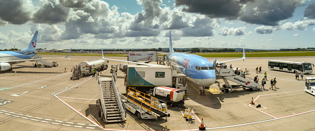 Bristol, England - August 2019:   Panoramic view of a TUI Boeing 737 holiday jet surrounded by ground equipment at Bristol Airport.