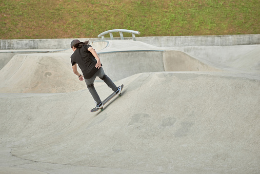 Asian young man with skateboard in a skate park
