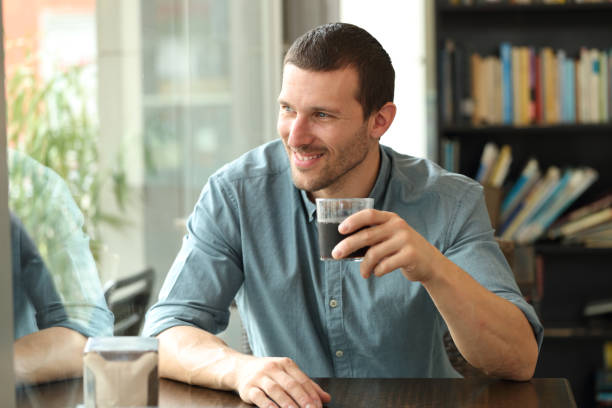 istock Happy man looking throw window in a coffee shop 1263640877