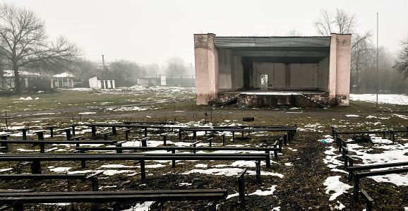 Old abandoned stage and broken benches. Depressed landscape