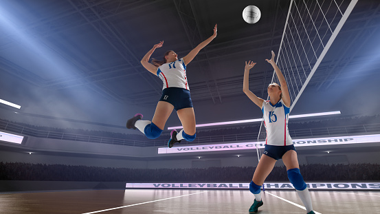 Female volleyball player spiking the ball during game at sports court