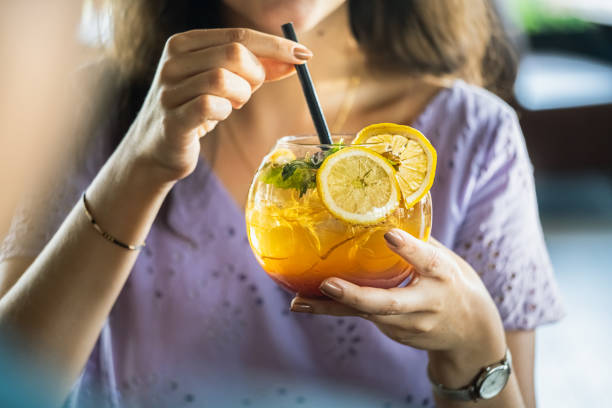 istock Woman hand holding iced yellow cocktail 1263643063