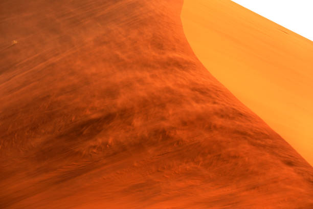 Majestic sand dune rises towards a cloudy sky, showcasing the beauty and power of nature in the desert