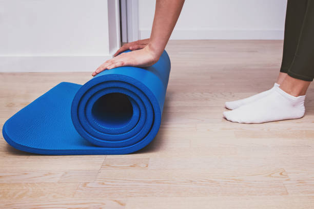 istock Woman rolling her mat after a yoga class or workout at home. 1263644618