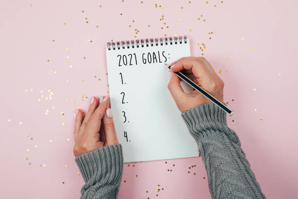 feliz año nuevo 2021. escritura a mano de mujer 2021 objetivos en cuaderno - propósito de año nuevo fotografías e imágenes de stock