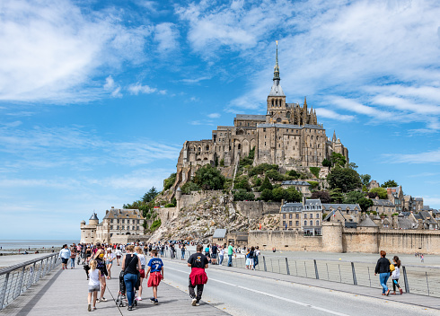 Mont St. Michel, France. Sunday 26 July 2020. Visitors walking on the bridge to Mont St. Michael in France, a popular historical tourist destination.