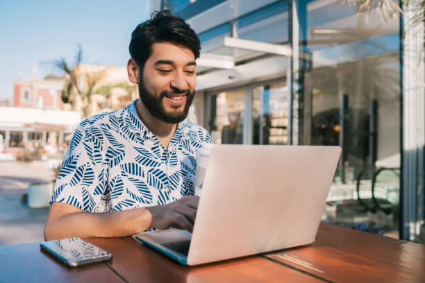 istock Young man using his laptop in a coffee shop. 1263646396