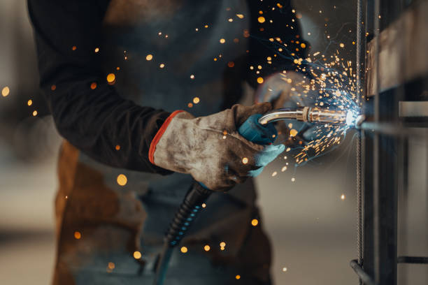experienced welder works in the factory - manual worker portrait helmet technology imagens e fotografias de stock