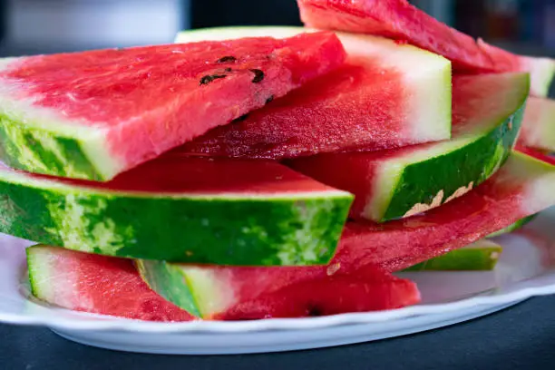 Watermelon slices stacked on a white plate - close up