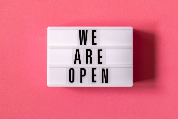 istock Signboard WE ARE OPEN of lightbox on red wall background 1263656614