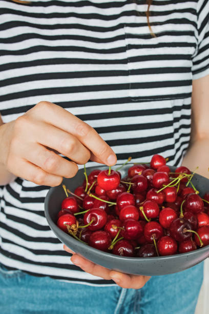 istock Woman's hand holding bowl of fresh cherries 1263657745