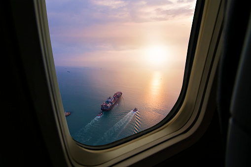 Aerial view of cargo ship in transit. View from airplane window.