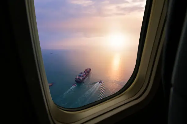 Photo of Aerial view of cargo ship in transit. View from airplane window.